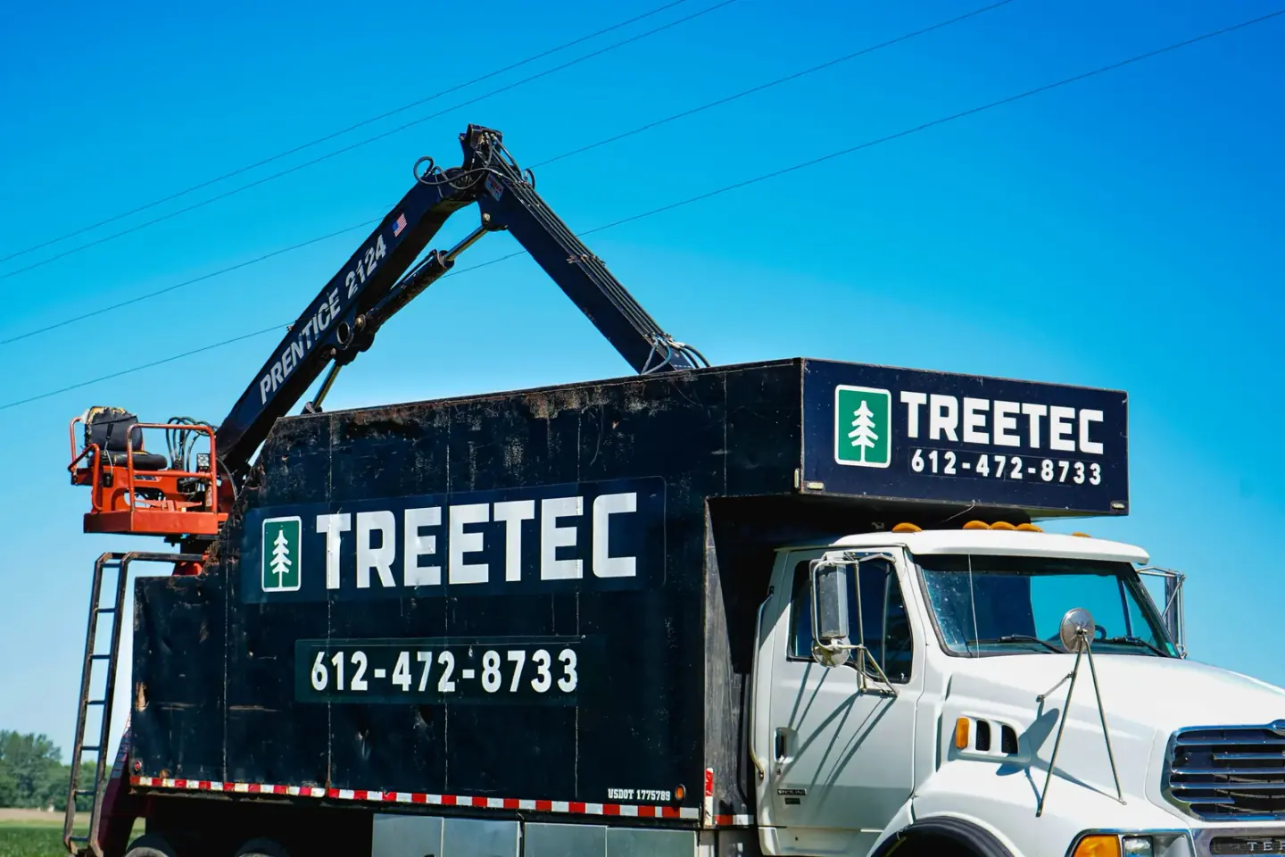 TreeTec grapple truck with the boom extended, loading wood