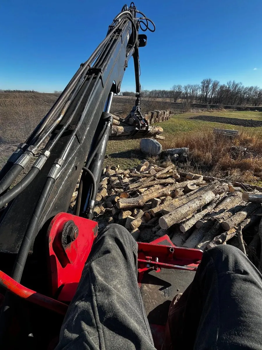 TreeTec grapple truck loading logs after a tree removal in central Minnesota